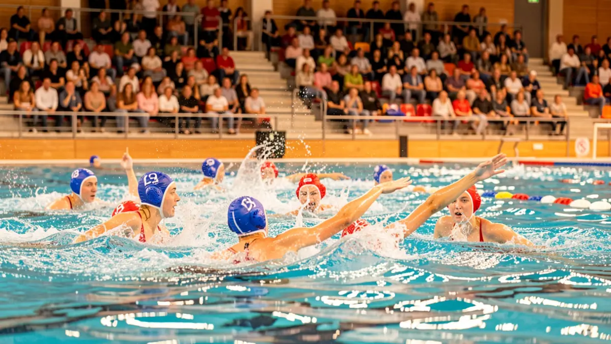 Jugadores de waterpolo competint en una piscina durant el Campionat d'Espanya Juvenil Femení a Terrassa.