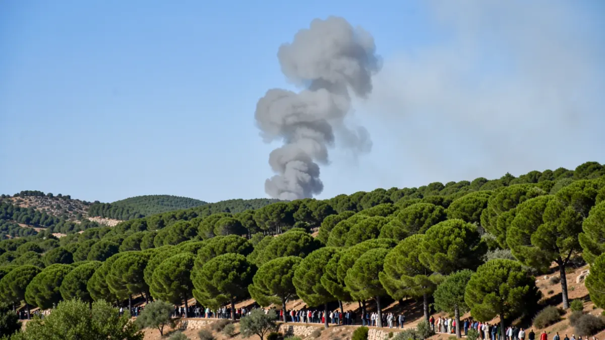 Columna de fum sobre una zona boscosa afectada per un incendi forestal.