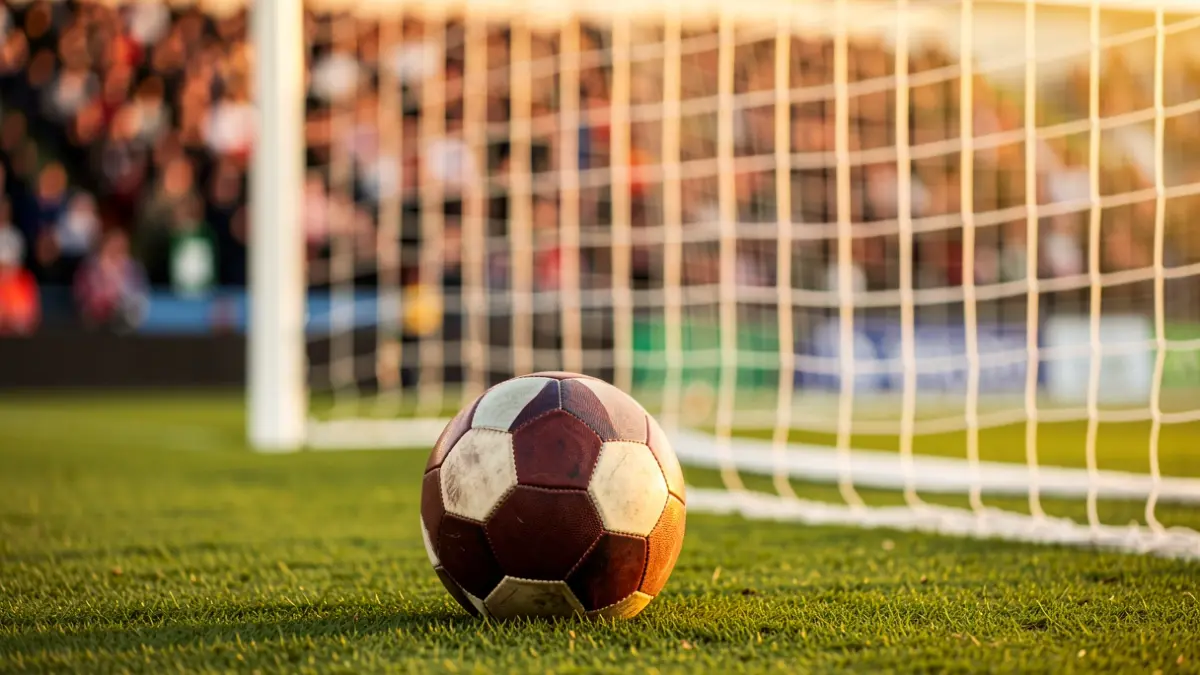 Imagen genérica de un balón de fútbol sobre el césped con la portería al fondo.