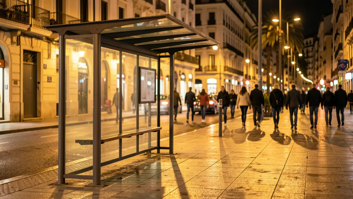 Parada d'autobús buida a la nit a Barcelona amb llums de carrer càlides.