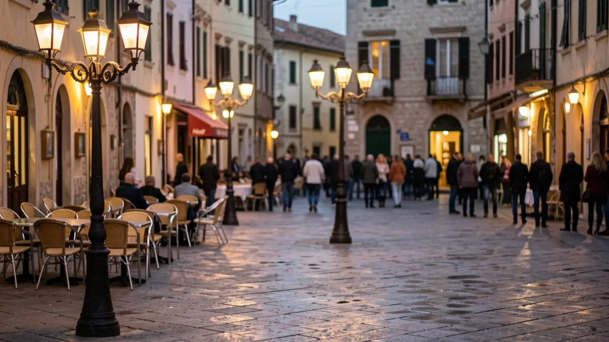 Imatge genèrica d'una plaça de poble mediterrani al vespre, amb enllumenat públic i mobiliari urbà.