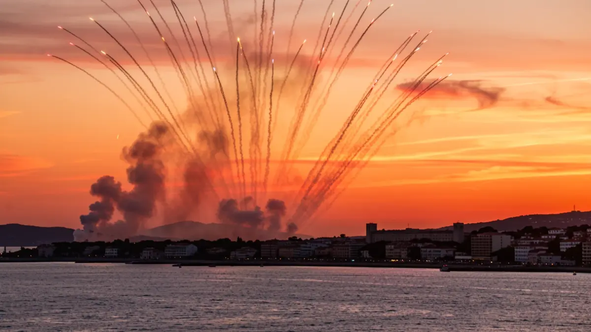 Imagen genérica de un espectáculo aéreo al atardecer sobre el mar Mediterráneo con humo y fuegos artificiales.