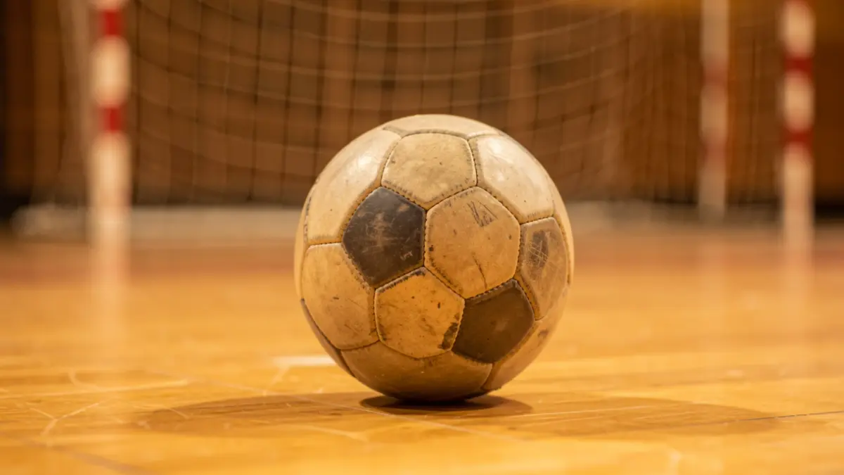 Imatge genèrica d'una pilota d'handbol sobre el terra d'un pavelló esportiu.
