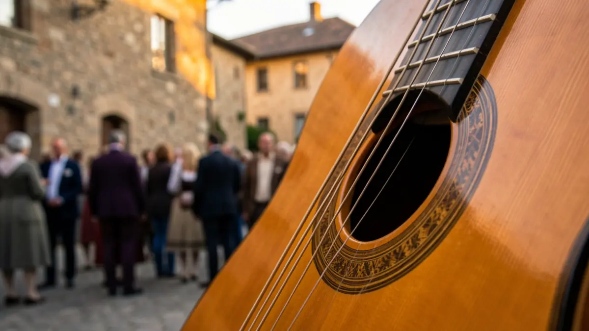 Primer pla d'una guitarra clàssica amb fons difuminat d'una masia i llum càlida.