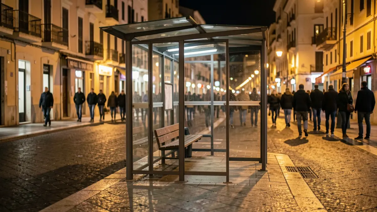 Imatge genèrica d'una parada d'autobús buida a la nit en una ciutat mediterrània.