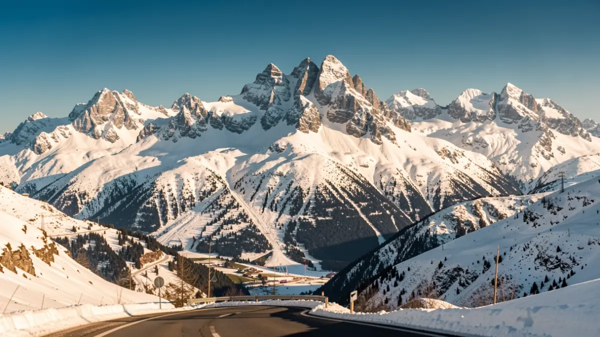 Imatge genèrica de muntanyes nevades amb una carretera i un cel blau.