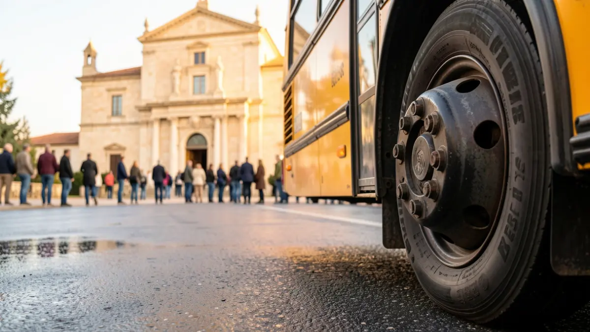 Generic image of a school bus wheel on wet asphalt, with a blurred Mediterranean town hall facade in the background.